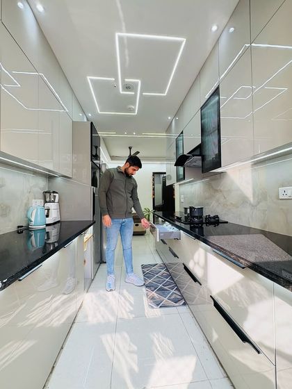 A full view of the completed parallel kitchen, showcasing the sleek, handleless design and the effective use of lighting to make the space feel bright and open.