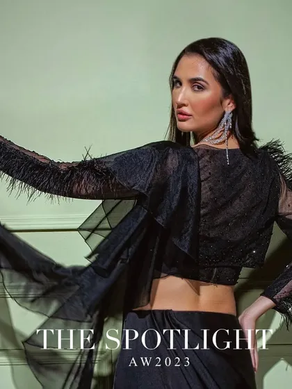 The back view of the black drape saree with feather-detailed sleeves, adding a touch of drama and high fashion.