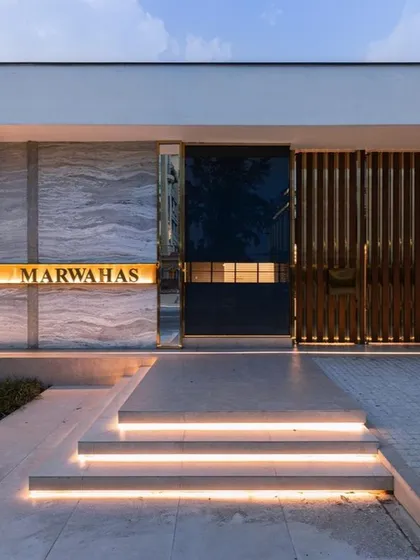The grand entrance to a modern residence, featuring a mix of materials like marble, wood, and metal. The illuminated steps and glowing nameplate create a luxurious and welcoming first impression, showcasing our skill in hardscape and entrance design.