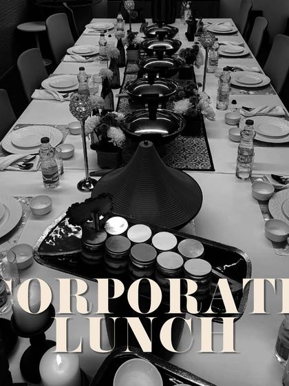 A sophisticated black and white themed corporate lunch setup. The long table is elegantly set, demonstrating my ability to create a formal and impressive dining experience for business clients.