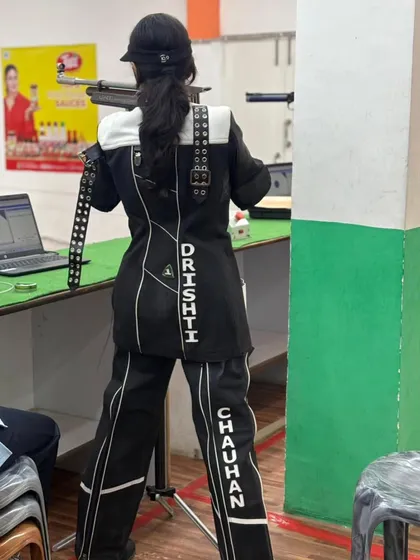 A shooter in full competition gear, demonstrating the focus and form required for 10m air rifle events.
