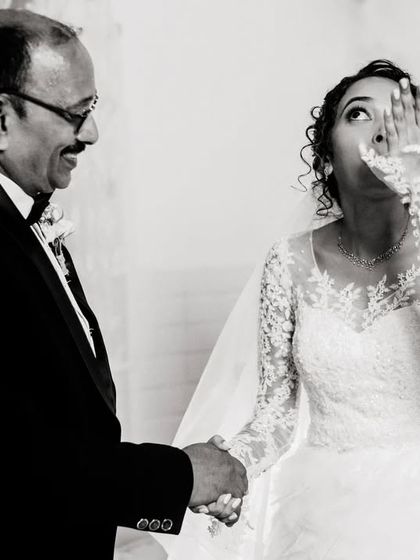 A candid, black and white shot of a bride sharing a happy, emotional moment with her father. The connection between them is clear and beautiful.