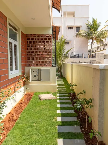 A narrow garden path beside the house, showing how greenery can be used to soften the building's edges.