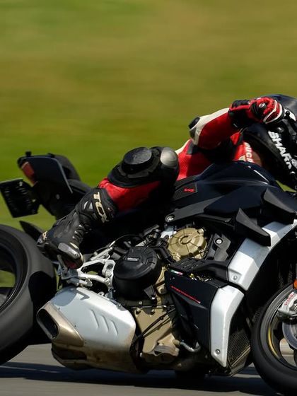 A low-angle shot of the Ducati Streetfighter V4, emphasizing the extreme lean angle and the rider's skill.