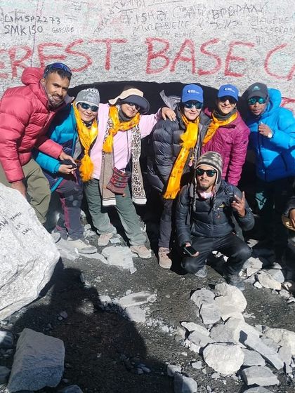 A triumphant group photo at Everest Base Camp. Our patient, who recovered from severe knee osteoarthritis, stands proudly with her trekking group, a testament to her hard work and our tailored therapy program.