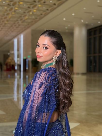 This shot highlights the sleek, high ponytail and the way the makeup enhances her profile, creating a sharp and polished silhouette perfect for an evening event.