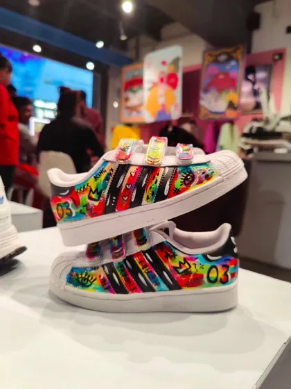 Even the kids' shoes got a custom touch! I painted these children's Superstars with a vibrant, graffiti-style design.