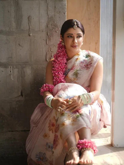 A soft and dreamy portrait of Nyra Banerjee in a floral organza saree. This look was designed to evoke a "happy village girl" vibe, with fresh flower jewelry and minimal makeup.