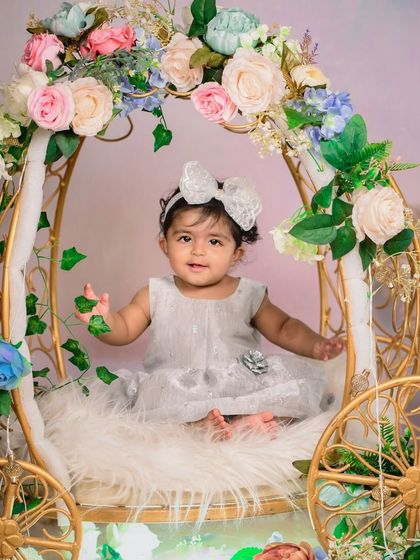A sweet portrait in the floral carriage. The soft fur lining and surrounding flowers create a cozy and beautiful setting for your little one.