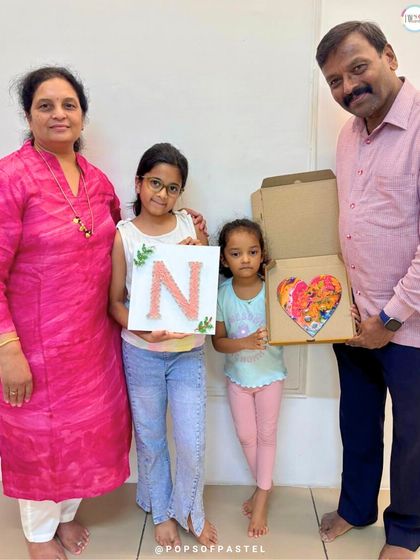A beautiful family portrait. Grandparents and an instructor pose with two young artists and their finished pieces, celebrating a day of creativity.