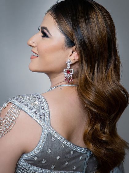 A close-up on a modern silver-grey blouse with unique shoulder detailing. This rental is for the fashion-forward guest.