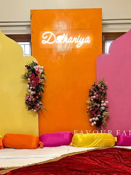 A modern and colorful 'Shaadi ka ghar' setup for a pre-wedding celebration at home. We used bright, arch-shaped panels and a 'Dulhaniya' neon sign to create a fun photo booth area.