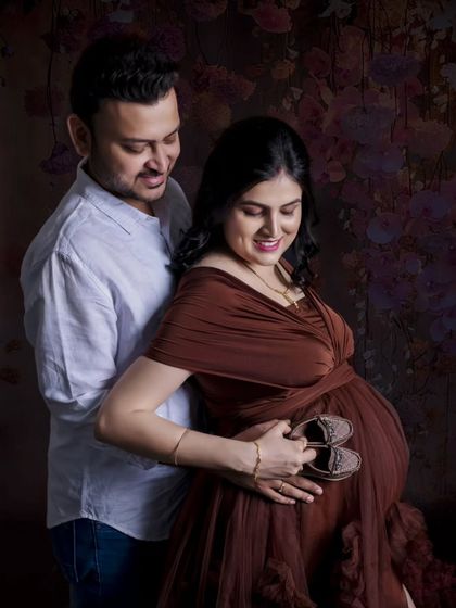 A close and loving moment as the couple looks down at the tiny shoes they hold against the baby bump. It's a shot filled with quiet anticipation.