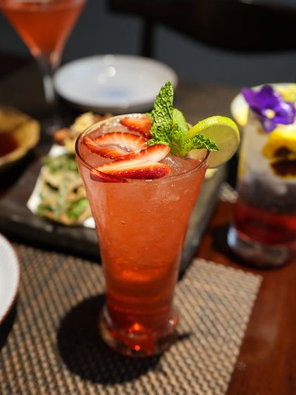 A refreshing strawberry mocktail, garnished with fresh mint and lime. A perfect non-alcoholic option to enjoy with your meal.