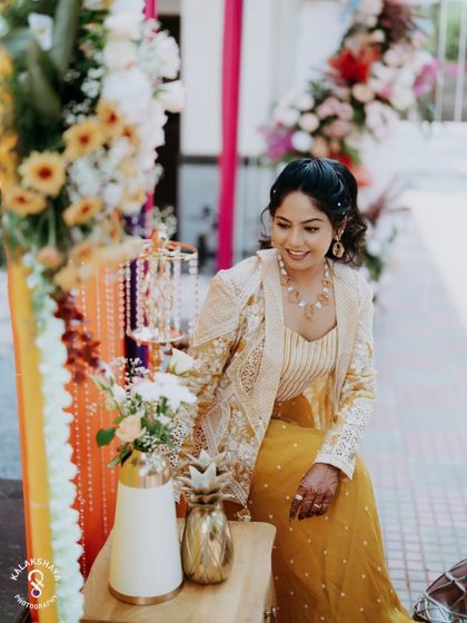 A candid shot of the bride-to-be, smiling brightly during her colorful carnival-themed event.