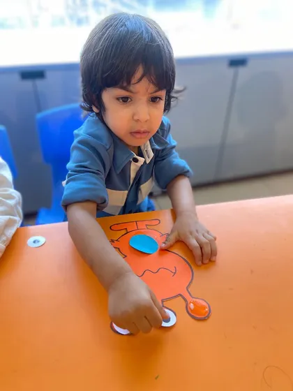 This little one is carefully placing a piece on his alien craft. Each step in the crafting process is a small victory that builds confidence.