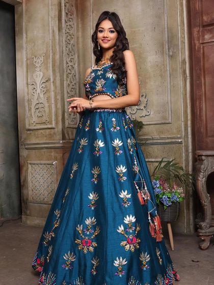 The full look. The vibrant blue lehenga is perfectly complemented by the colorful makeup, creating a look that is both cohesive and eye-catching.