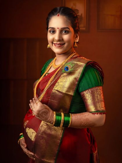 A close-up portrait highlighting the beautiful details of the traditional saree, jewelry, and the mother's happy glow.