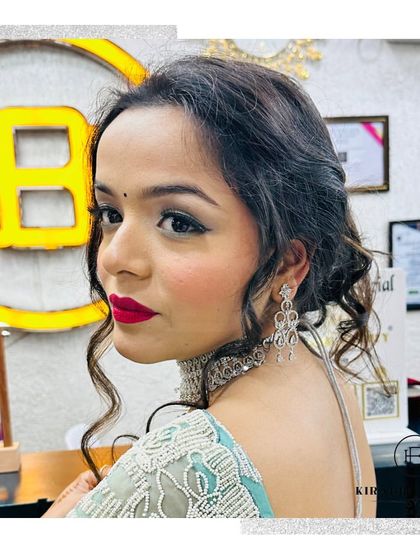 A side profile showcasing the elegant hairstyle and makeup. The soft curls and dramatic red lip create a very glamorous look.