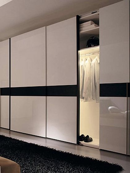 This conceptual design shows a large sliding wardrobe with high-gloss white shutters and a bold black accent stripe, creating a striking and modern aesthetic.