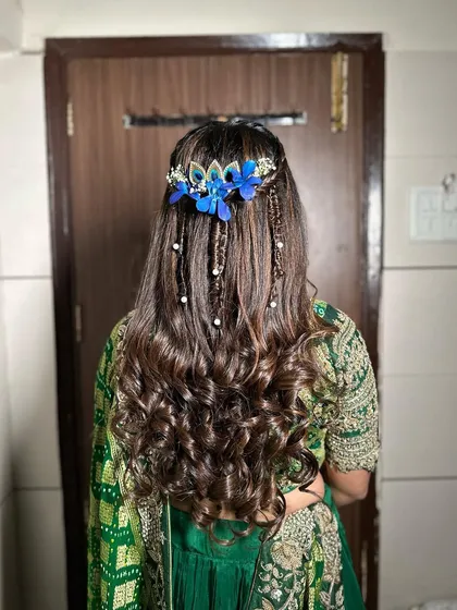 A detailed back view of the boho-chic hairstyle. The combination of braids, pearls, and flowers is unique and eye-catching.