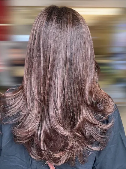 A smokey mocha brown layered look. This is a modern and chic style that combines a cool-toned brown with a flattering cut.