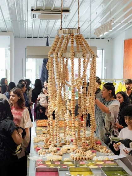 A wide shot of the crowd at the Studio Medium store launch, gathered around the bread chandelier. The event was a wonderful example of how food and fashion can intersect in a creative and exciting way.