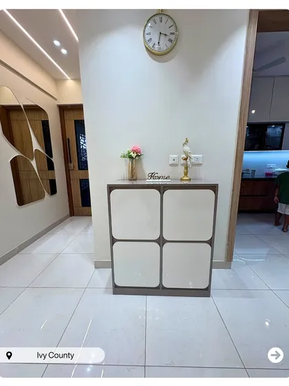 A minimalist and chic entryway at Ivy County. The simple shoe cabinet and elegant wall clock create a clean and welcoming first impression.