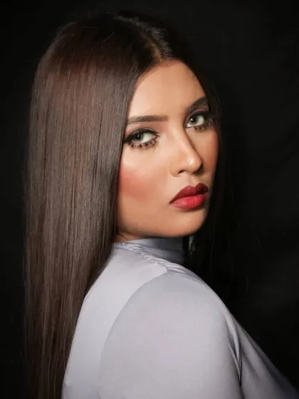 A profile view that shows the sleekness of the hair and the strong lines of the makeup.