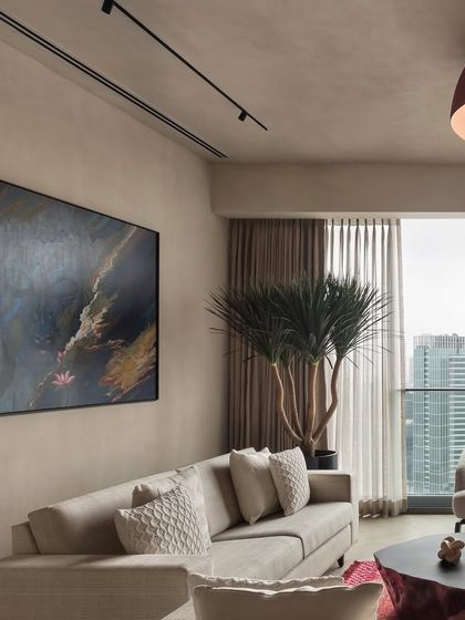 A large abstract painting serves as a stunning focal point in the East Coast Residence living room. The colors in the artwork are echoed in the rug, tying the whole space together.