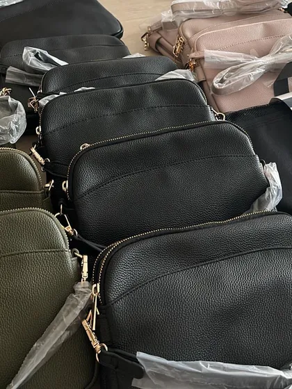 A close up of the crossbody bags sourced from Australia. You can see the black, olive, and pink colours all ready to go to their new homes.