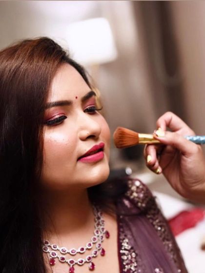 A close-up of the makeup application, showing the vibrant pink eyeshadow being applied for the Roka ceremony.