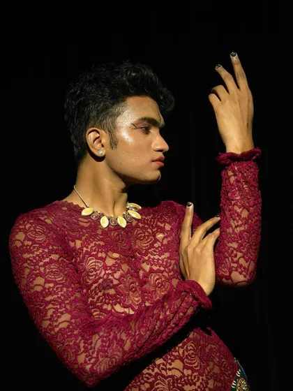 A close-up shot of a creative makeup look for dancer Niraj Patel. This look features a glossy, highlighted skin finish and defined eyes, suitable for an artistic photoshoot.