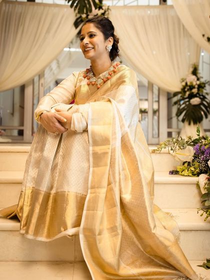 Our co-founder Pooja epitomizes elegance in a double-layered blouse ensemble with a classic white and gold Kanjeevaram saree.
