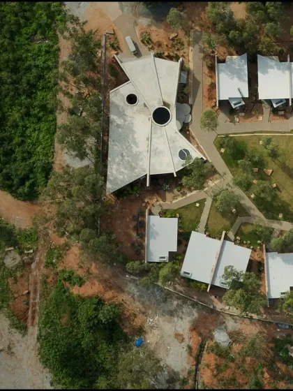 A top-down view of the completed resort area, showing the relationship between the main building, individual cottages, and the landscaped green spaces that connect them.