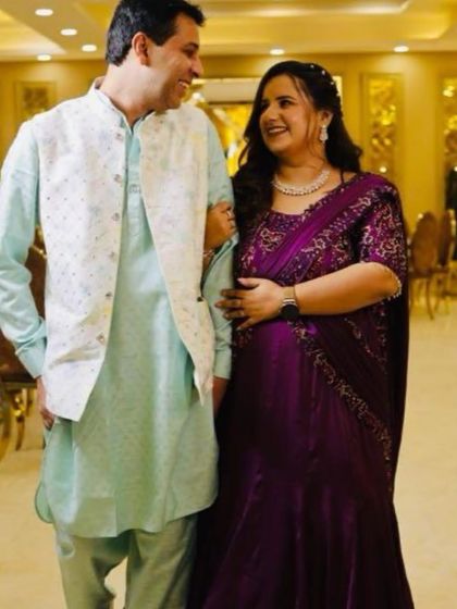 A candid moment showing off this beautiful custom-draped saree gown. The rich purple color and the embroidered blouse blend tradition with a modern silhouette.