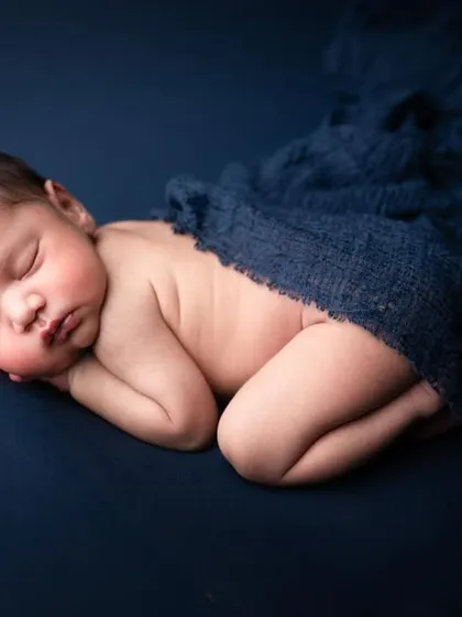 This is one of our most classy newborn poses. The deep blue fabric creates a rich contrast that highlights the baby's soft skin, resulting in a minimalist and gorgeous portrait.
