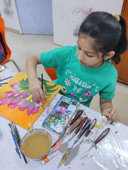 Watch the step-by-step process as a student paints a bright and cheerful bouquet of tulips on a yellow background.