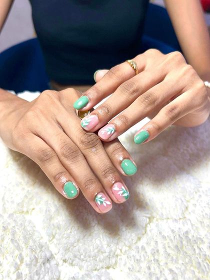 A lovely, simple design on natural nails. I used a mint green polish and added delicate white leaf art on the accent nails.