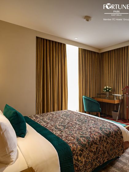 This room features a stylish patterned bedspread and a work desk by the window. It’s a quiet and comfortable space designed for both productivity and relaxation.