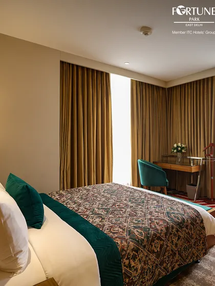 This room features a stylish patterned bedspread and a work desk by the window. It’s a quiet and comfortable space designed for both productivity and relaxation.