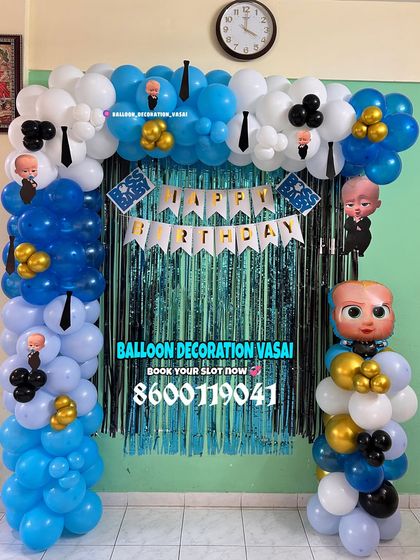 A simple Boss Baby decoration for a home party. This balloon arch in blue, white, and black is set against a shimmer curtain, with a character foil balloon.