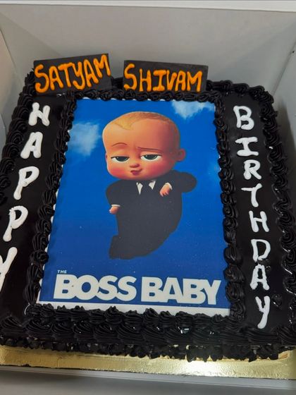 A Boss Baby photo cake, perfect for a chocolate lover. The edible poster is framed with dark chocolate frosting, and the names of the birthday boys are highlighted on top.