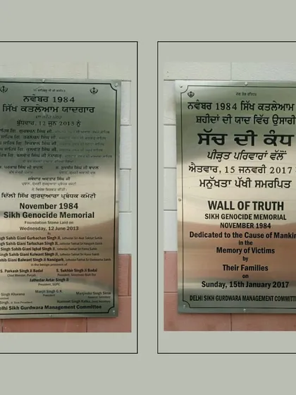 Dedication plaques at the Sikh Genocide Memorial, inscribed in both Punjabi and English. These texts officially name the site and dedicate it to the victims, providing crucial context for understanding its purpose and patronage by the Delhi Sikh Gurdwara Management Committee.