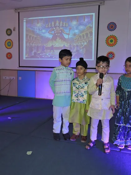 Students dressed in traditional kurtas stand on stage to narrate parts of the Dussehra story, building their public speaking skills.