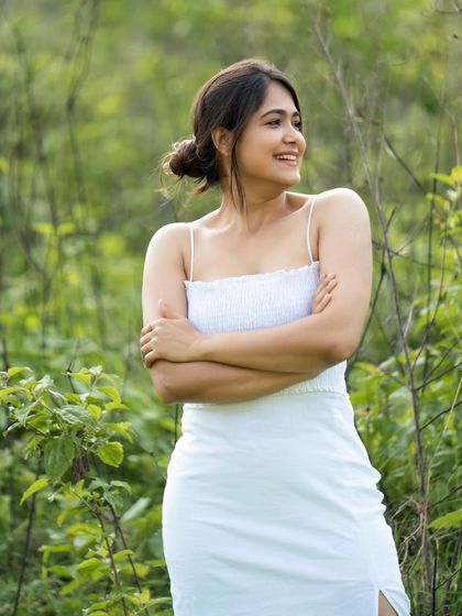 Another shot from the white dress series, this one capturing a candid, happy moment. The natural lighting and relaxed pose feel authentic and relatable.