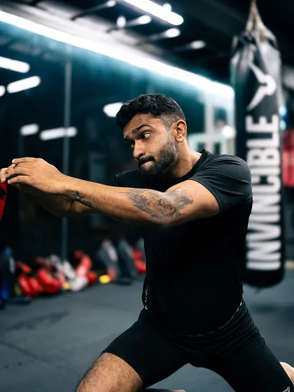 A coach demonstrates proper form for a striking technique during a class.