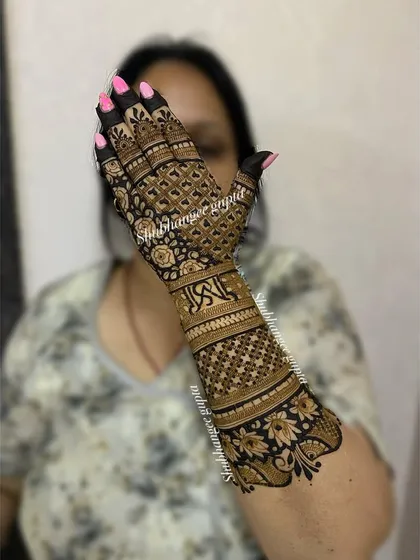 A traditional back-of-hand design with the couple's initials woven into the pattern. The dense jaal work and floral borders create a classic and timeless bridal look.