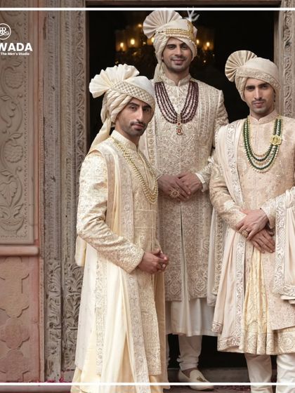 Three grooms stand together, each in a unique sherwani from the Shauhar collection. The image highlights variations in embroidery, draping, and accessories, showing how each piece is tailored to a personal style while maintaining a cohesive royal aesthetic.