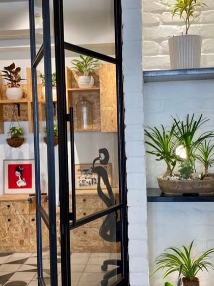 This view shows how I integrate plants into a functional workspace. By placing plants on shelves, in hanging baskets, and on built-in ledges, I can add life to every corner of a room, as seen in this modern office design in Powai.